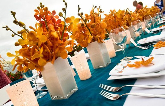 To make this work think teal satin linens orange flowers like dahlias and 